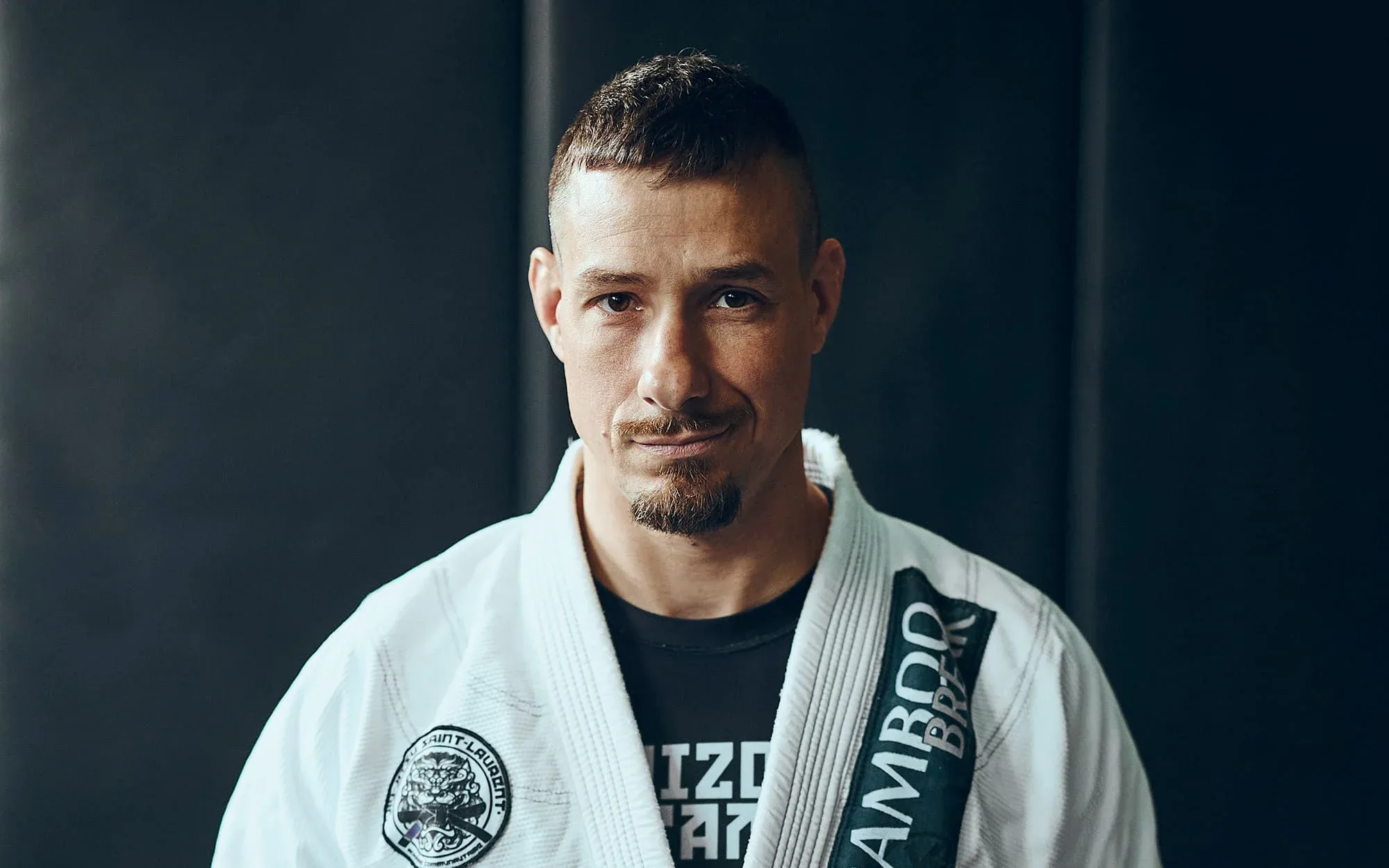 A man in a white kimono looking at the camera with determination and compassion