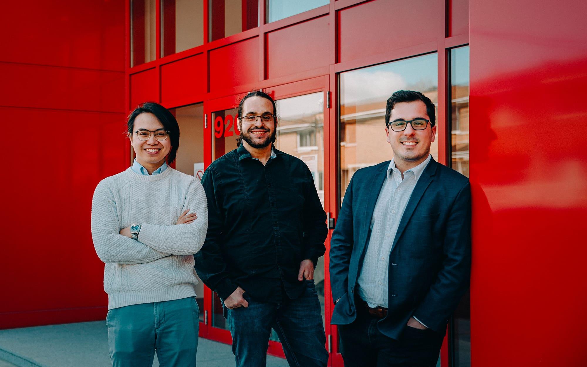 trois entrepreneurs devant un bâtiment rouge
